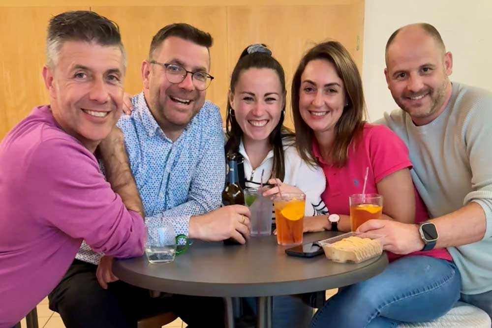 Fünf Mitarbeiter von FeBe um einen Tisch mit Drinks und Snacks.